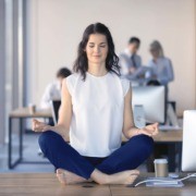 Woman meditating on desk at work